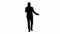 Silhouette Successful man in suit speaks on phone and walks.