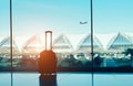 Silhouette suitcase,luggage on side window at airport terminal international and airplane outside on fly flight in the blue sky tr Royalty Free Stock Photo