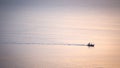 Silhouette sunrise of minimal fishery boat sail on calm sea