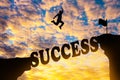 Silhouette sunset background. A man are jumping over to cliff and jump across success word. Royalty Free Stock Photo