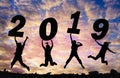 Silhouette sunset background and New year.They are jumping in to sky and lift 2019 word.