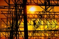 Silhouette sunset of construction worker working in large metal structure of commercial building
