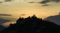 The silhouette of the sunset, a group of young people standing on the top of the mountain watching the sunset