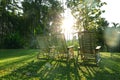 Silhouette sunset three wooden armchair on green grass field and