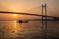 Silhouette sunset of Vidyasagar bridge with a boat on river Hooghly