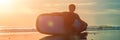 Silhouette of surf man sitting with a surfboard on the seashore beach at sunset time BANNER, long format Royalty Free Stock Photo