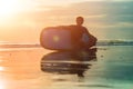 Silhouette of surf man sitting with a surfboard on the seashore beach at sunset time Royalty Free Stock Photo