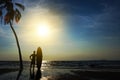 Silhouette of surf man stand with a surfboard and coconut palm. Royalty Free Stock Photo