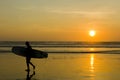 Silhouette of a Surfer carrying his surfboard on Kuta Beach at a golden Sunset Royalty Free Stock Photo