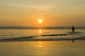 Silhouette of a Surfer carrying his surfboard on Kuta Beach at a golden Sunset Royalty Free Stock Photo