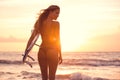 Silhouette surfer girl on the beach at sunset Royalty Free Stock Photo