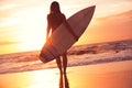 Silhouette surfer girl on the beach at sunset Royalty Free Stock Photo