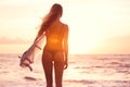 Silhouette surfer girl on the beach at sunset Royalty Free Stock Photo