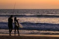 A Surfer Girl and Fisherman at Sunset.