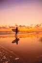Silhouette with surfer girl and surfboard on a beach at warm sunset or sunrise. Surfer and ocean Royalty Free Stock Photo
