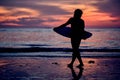 Silhouette of a surfer heading