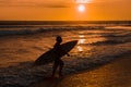 Silhouette of surfer with surfboard walking on the beach in sunset Royalty Free Stock Photo