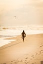 Silhouette of surfer walking on the beach during sunset Royalty Free Stock Photo