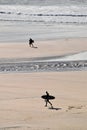 Silhouette Surfers on Godrevy beach at low tide Cornwall UK 