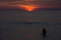 Beautiful dramatic sunset and silhouette of a diver, swimmer Royalty Free Stock Photo