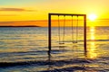 Silhouette of swing at amazing sunset on the beach Royalty Free Stock Photo