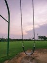 Silhouette of swing set at dusk with puddles of water during monsoon