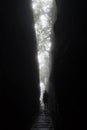 Silhouette of a tall unrecognisable woman as she looks out from a dramatic cleft in the rocks of the mountains of Madeira island. Royalty Free Stock Photo