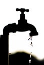 Silhouette of a tap dripping water Royalty Free Stock Photo