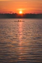 Silhouette of Team work oft two young men in a row boat at sunset Royalty Free Stock Photo