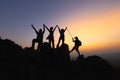 Silhouette Teamwork of four hiker helping each other on top of mountain climbing team beautiful sunrise. Teamwork friendship