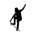 Silhouette of teenage skateboarder doing trick on skateboard Royalty Free Stock Photo