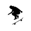 Silhouette teenage skateboarder jumping sideways