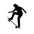 Silhouette of teenage skateboarder learning trick on skateboard Royalty Free Stock Photo