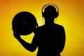 Silhouette of a teenager who holds the LP in front of yellow background