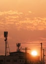 Silhouette of telecommunication tower with antennas on top of building against sunset sky background Royalty Free Stock Photo