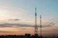 Silhouette, telecommunication towers with TV antennas and satellite dish in sunset, panorama composition