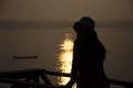 Silhouette thai women with long tail boat and reflection light surface water of Mekhong River and lighting of Sun in morning time Royalty Free Stock Photo