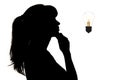 Silhouette of thoughtful woman looking at the incandescent lamp upwards, thought bulb, concept of idea on white isolated backgroun Royalty Free Stock Photo