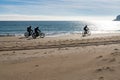 Silhouette of three bikers cruising along a secluded beach with fat tire bikes Royalty Free Stock Photo