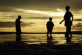 Silhouette of three boys playing with the ball on the beach at during sunrise Royalty Free Stock Photo