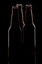 Silhouette of three brown beer bottles