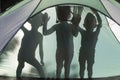 Silhouette of three children behind a tent