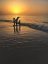 Silhouette of three kid on the bech at sunset