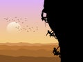 Silhouette of three mountain climbers climbing with sunset background