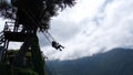 Silhouette of a tourist on a swing at Casa del Arbol