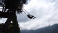 Silhouette of a tourist on a swing at Casa del Arbol