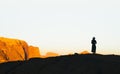 Silhouette of tourist woman on cliff greet sunrise in Jordan desert of Wadi Rum Royalty Free Stock Photo