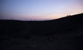 Silhouette tourists on Etna Volcano at sunset light