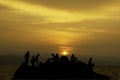 Silhouette of tourists Fishing on the rocks in sea and Golden light of sunrise behind the mountains Royalty Free Stock Photo