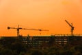 Silhouette tower crane and building on site Industrial construction on sunset background Royalty Free Stock Photo